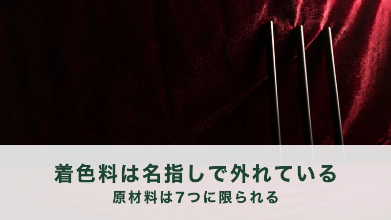 暗い赤の布の前に、細い黒檀の棒が三本だけ立てかけてある