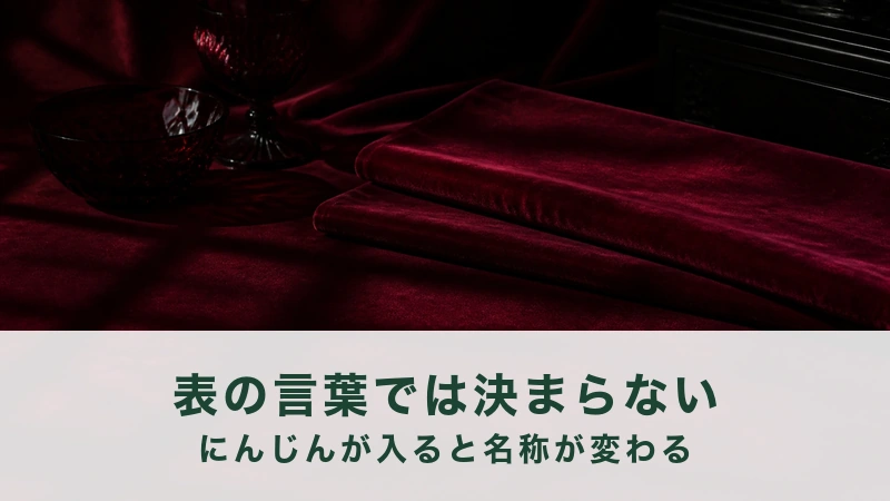 淡い光の下で、えんじ色のビロードの帯が二枚重ねて置かれている