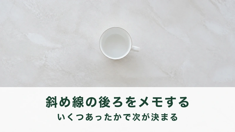 中が空の白い琺瑯のマグを真上から見る。斜め線の後ろを書き留める結び