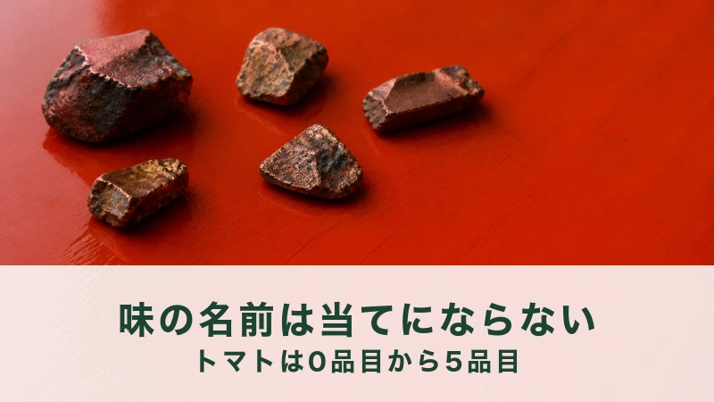 朱色の漆の板に、赤銅色に酸化した金属のかけらが五つ散らばっている