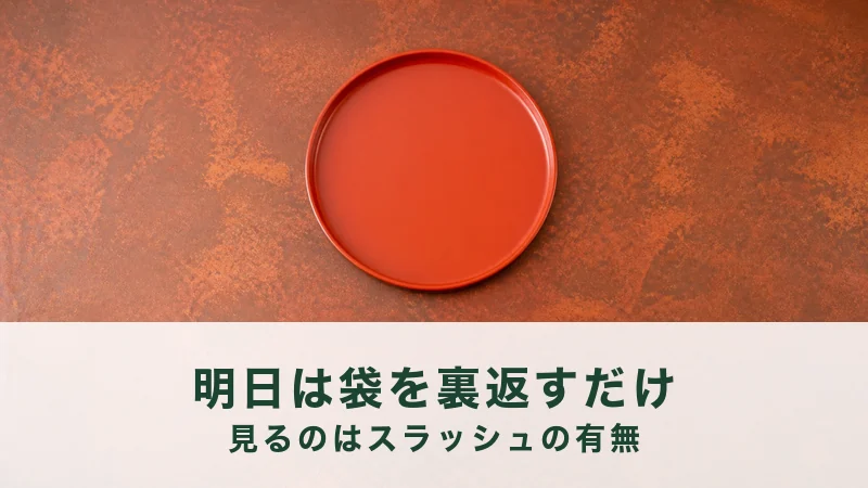 錆びた赤銅色の面の中央に、朱色の漆の丸盆が一枚だけ、上に何も乗せずにある