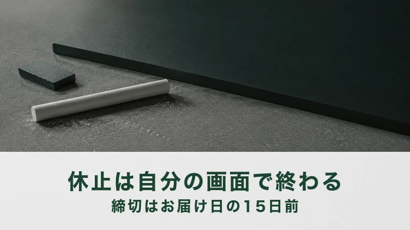 灰色の台に黒い板を伏せて置き、手前に白墨と黒い消し具が転がっている
