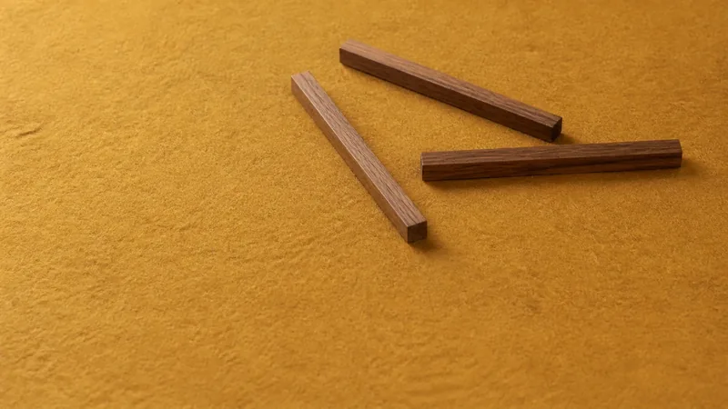 黄土色の布の上に、こげ茶の細い角材を3本ならべた