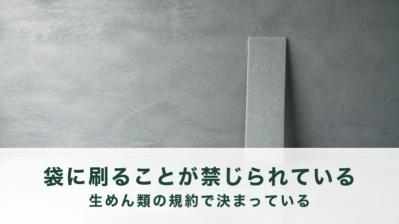 暗い灰色の壁を背に、縦長の板が1枚まっすぐ立っている