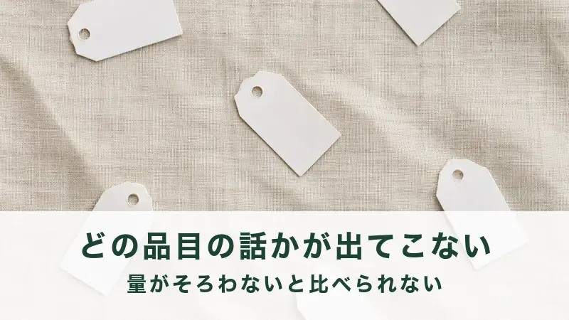 生成りの布に、値札のような白い小さな紙が数枚散らばっている