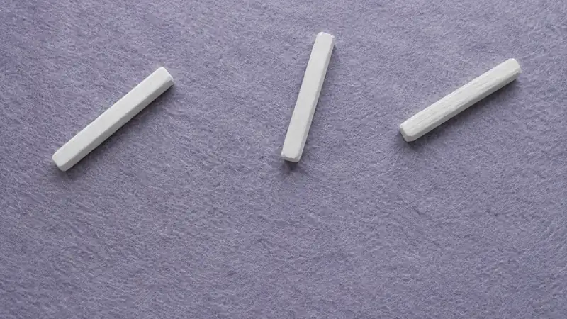 薄紫の布の上に斜めに置いた三本の白い短い棒