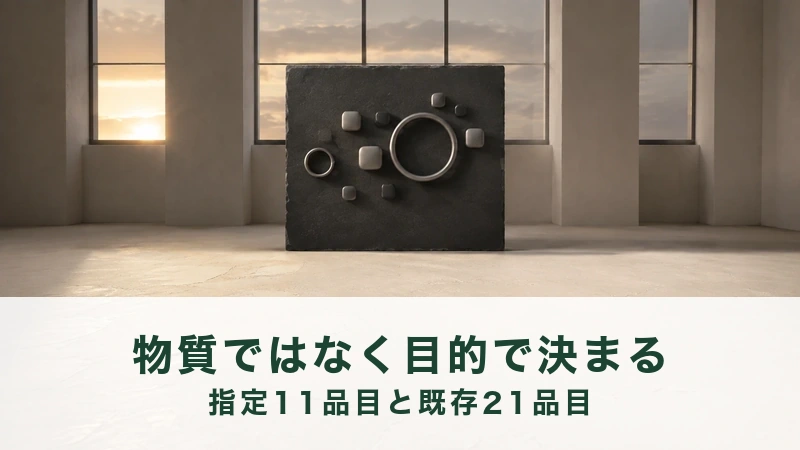 窓辺のコンクリート床に、黒い板と丸い粒がいくつか置かれた静かな部屋