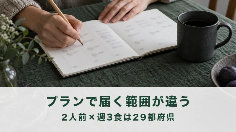 食卓に広げたノートに週の食事の予定を書き込む手元