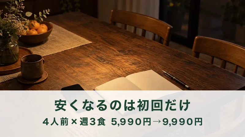 夜の食卓に置かれたノートとペン、奥に果物の器