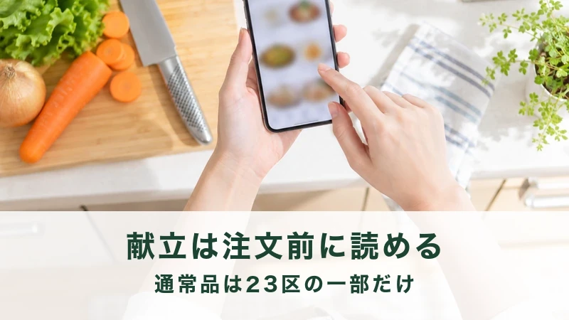 まな板の横でスマートフォンの献立ページを見ている手元