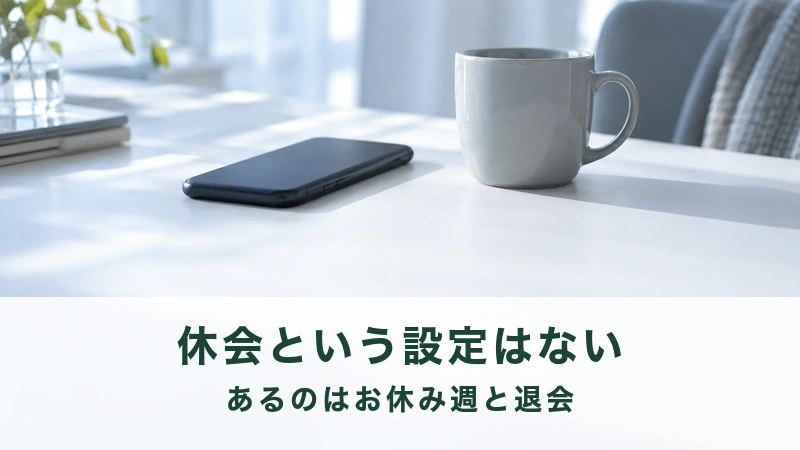 黒いスマートフォンとマグカップを置いた朝の白い机