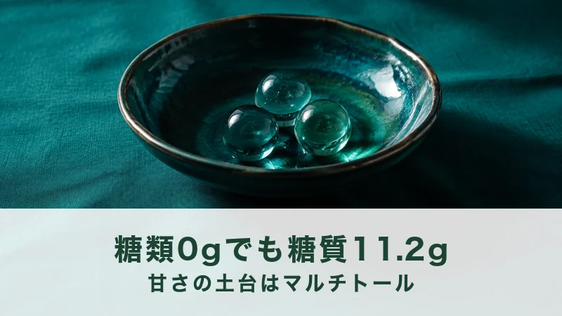 深緑のリネンに置いた緑の釉薬の浅鉢に、透明な青緑のガラス玉が3つ